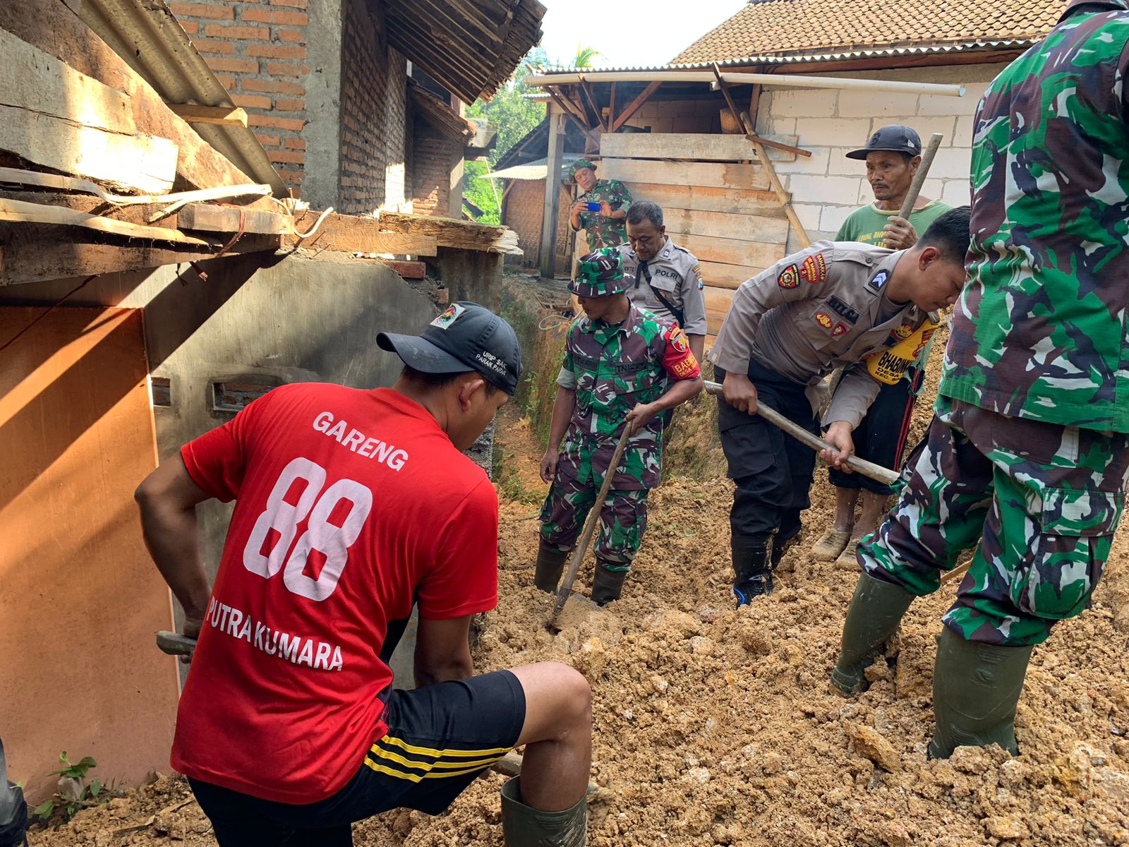 Sinergitas Polisi Bersama TNI Bersihkan Tanah Longsor yang Timpa Rumah Warga di Trenggalek